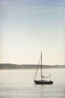 © MACO - Sail boat sailing in bay with land in the background.