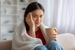 © Prostock-studio - Distressed young asian woman suffering from a headache or cold at home