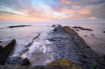 Wall Mural - North Sea washes over Howick Rocks, on the rocky shoreline  at Howick on the Northumberland coast, AONB which is now renamed as National Landscapes