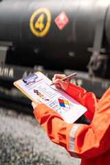Wall Mural - action of an engineer is checking on chemical hazardous material checklist form with background of t