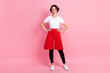 © deagreez - Full length body size photo woman confident wearing white t-shirt red apron smiling isolated pastel pink color background