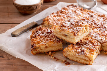 Streusel pie with jam filling on parchment. Selective focus, rustic style. Homemade bakery concept for background and wallpaper.