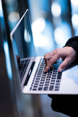 Male hacker in dark room using laptop internet hacking