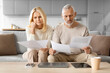 © Prostock-studio - Worried Senior Spouses Reading Papers And Bills At Home
