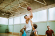 © Marko Geber - Basketball players playing basketball in an indoor basketball gym
