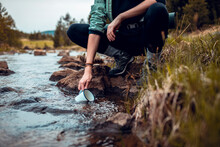 Hiker Filling Water Bottle From A Mountain Stream