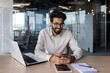 © Tetiana - Indian businessman working in office environment on laptop and smartphone