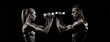 Two Athletic Individuals Engaging in an Intense Dumbbell Workout Against a Black Background