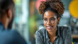 © The Humani Stock - A manager providing feedback and coaching to a team member in a one-on-one meeting. Portrait of a black woman in the office working.