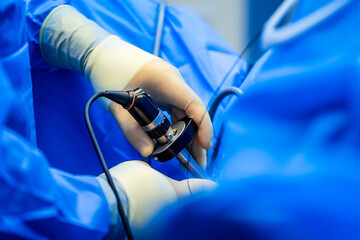 Surgeon is operating on patient using surgical microscope.