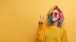 © Nataliia_Trushchenko - Attractive girl pink color hair pointing by index finger up to place for copy space. copy space for goods promotion advertisement. isolated alone on yellow studio background.