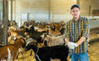Farmer does the cleaning in the goat shed
