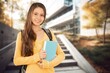 © BillionPhotos.com - Positive young female student hold books