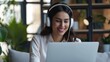 © buraratn - Head shot happy young indian ethnicity female manager wearing wireless headphones, looking at laptop screen, holding pleasant conversation with partners clients online