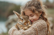 Girl with Easter bunny, adorable hug between a little girl and her fluffy pet, image for animal loving kids outdoors