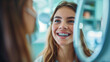 a young woman checks her smile after teeth cleaning, braces, and dental consultation. Healthcare, dentistry, and a happy female patient with orthodontist for oral hygiene, wellness and cleaning