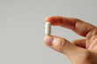 © Ari - Hand holding white pill, healthcare: medicine, antibiotic, supplement