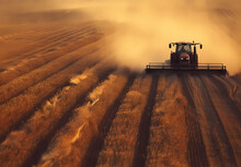 Tractor Plowing Through Dry Wheat Field On The Outskirts Of Farming