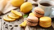 Deliciously moist macarons and tangy lemon wedges on a rustic wooden surface in close proximity.