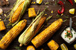Grilled corn on the cob on kitchen wooden table flat lay background