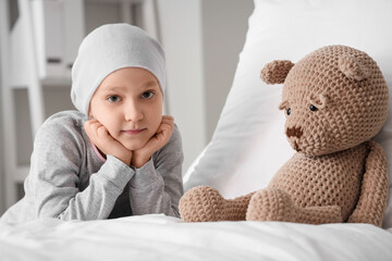 Sticker - Little girl after chemotherapy with toy on bed in clinic. International Childhood Cancer Day