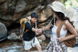 © itchaznong - Happy LGBT Lesbian couple Travelers Hiking with Backpacks in waterfall Trail. LGBT Lesbian Couple Hikers with backpacks walks in mountains in vacation