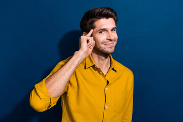 Canvas Print - Photo portrait of attractive young man touch temple create business plan wear trendy yellow clothes isolated on dark blue color background