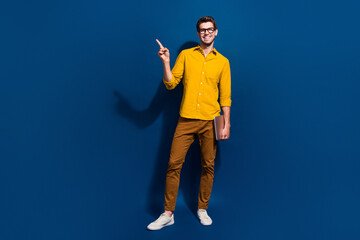 Fototapete - Full length photo of nice young male netbook specs point empty space dressed stylish yellow garment isolated on dark blue color background