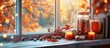 Fall-themed decorations including pumpkin-shaped candles, jars filled with nuts and candy corn, books on a windowsill, and an abstract window backdrop create a cozy composition for the autumn season.