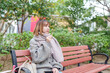 冬の寒い香港尖沙咀の公園で過ごす20代の中国人女性 A Chinese woman in her 20s spending time in a park in Tsim Sha Tsui, Hong Kong, which is cold in winter
