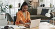canvas print picture - Black woman, typing in home office and laptop for research in remote work, social media or blog in apartment. Freelance girl at desk with computer writing email, website post and online chat in house