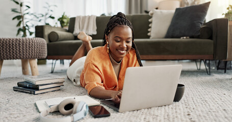 Poster - Laptop, smile and woman typing on the floor in the living room of modern apartment for research. Technology, happy and young African female university student studying on a computer in lounge at home