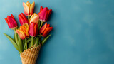 Fototapeta  - Wafer cone with tulips on a blue background. Flower ice cream, spring concept with first flowers, mother's day, birthday, top view.
