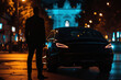 © ColdFire - Businessman stands on the side of the road at sunset. Man in a dark suit stands on the side of the road next to a luxury car