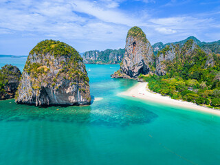 Top aerial drone view of the beautiful Railay Beach in Thailand. Panoramic view of an idyllic beach with huge limestone cliffs from above, turquoise ocean, tropical island