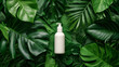 A bottle for cream without a label on a background of different tropical leaves, top view, soft light