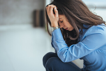 One Desperate stressed businesswoman sitting on the floor. The woman was stressed and disappointed by being fired. Concept of layoffs and unemployment.