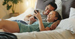 © HockleyMedia/peopleimages.com - Asian couple, phone and social media for communication and entertainment on bed to relax, laughing and watch funny videp in bedroom at home. Man and woman using 5g internet while lying together