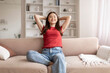© Prostock-studio - Smiling young asian woman enjoying moment of relaxation at home