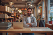 © Ishra - Happy Caucasian young male freelancer smiling while working in the laptop and seated in a charming place, vintage lighting interior, smiling boy wearing casual dress and looking at camera