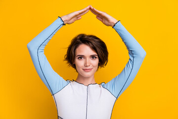 Sticker - Photo of cheerful positive woman wear top smiling showing arms roof isolated yellow color background