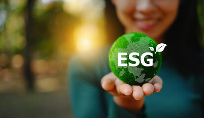 female hand holding a green ball, esg values and promoting the net zero concept for a sustainable an