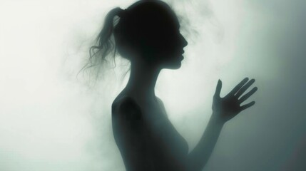 Wall Mural - Female silhouette on a light background. Elegant outline of a woman in motion out of focus