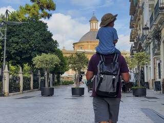 Wall Mural - Man with kid on shoulders walk beautiful Valencia streets