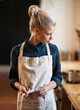 © Jeff Bergen/peopleimages.com - Chef, woman and tie apron in restaurant, kitchen or catering service at hotel for gastronomy. Uniform, cooking and person fasten clothes, culinary and preparation of professional waitress at job