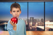 Child shows a red apple to the camera