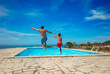 © Sergey Novikov - Family fun of father and kid with a poolside jump at resort