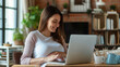 © Taisiia - Pregnant young woman working at home on laptop