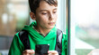 Child on social networks with his smartphone from school when leaving class. Concept of children using social networks and their dangers without parental control at school