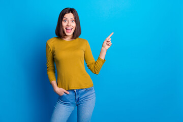 Wall Mural - Photo of positive impressed lady dressed shirt pointing finger empty space isolated blue color background